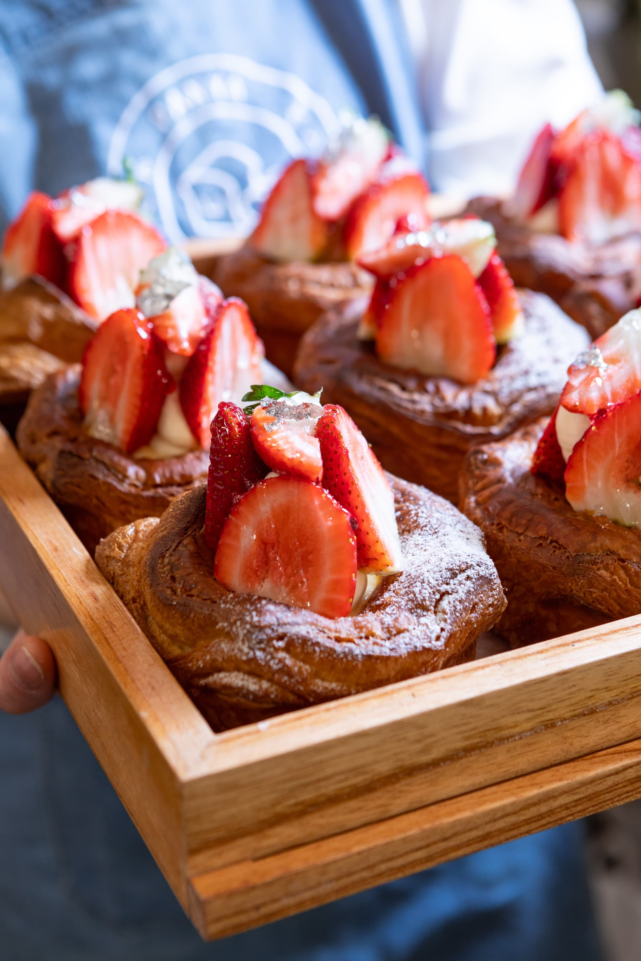 A tray of pastries topped with cut strawberries